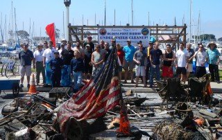 Volunteer divers posing with debris recovered during a Dana Point Harbor cleanup.
