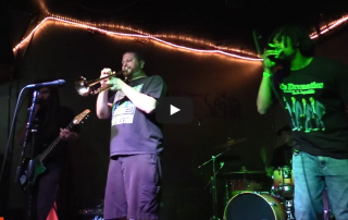 Musicians performing onstage at Que Sera.