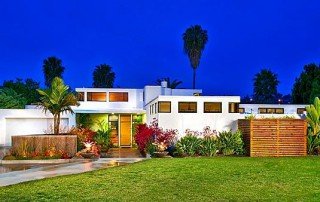 International Style home beside La Costa North Course photographed at dusk.