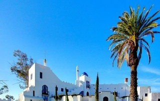 White church exterior and palm trees at Sister Aimee’s Castle in Lake Elsinore.